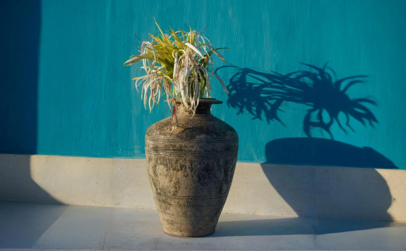 Khmer vase against a blue villa wall at Knai Bang Chatt